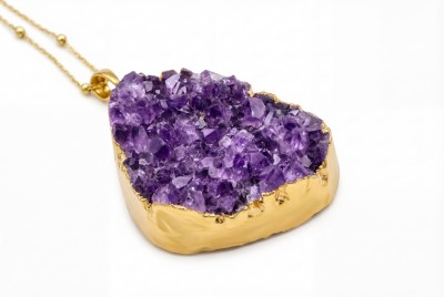 Naszyjnik z naturalną szczotką ametystu w pozłacanej oprawie na białym tle, biżuteria Brazi