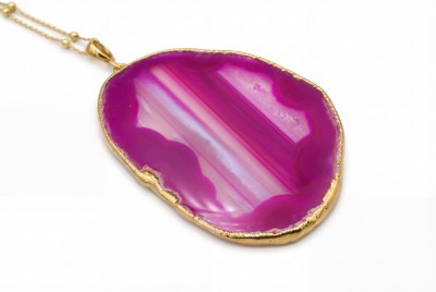 Naszyjnik z naturalnym plastrem agatu w kolorze fuksji, złocona oprawa o nieregularnej fakturze, biżuteria Brazi.