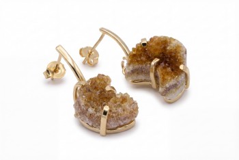 Detal naturalnej druzy cytrynu w pozłacanej oprawie kolczyków, biżuteria z minerałów Brazi.